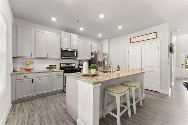a kitchen with a dining table chairs refrigerator and cabinets