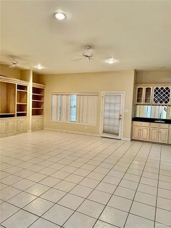 an empty room with windows and cabinet