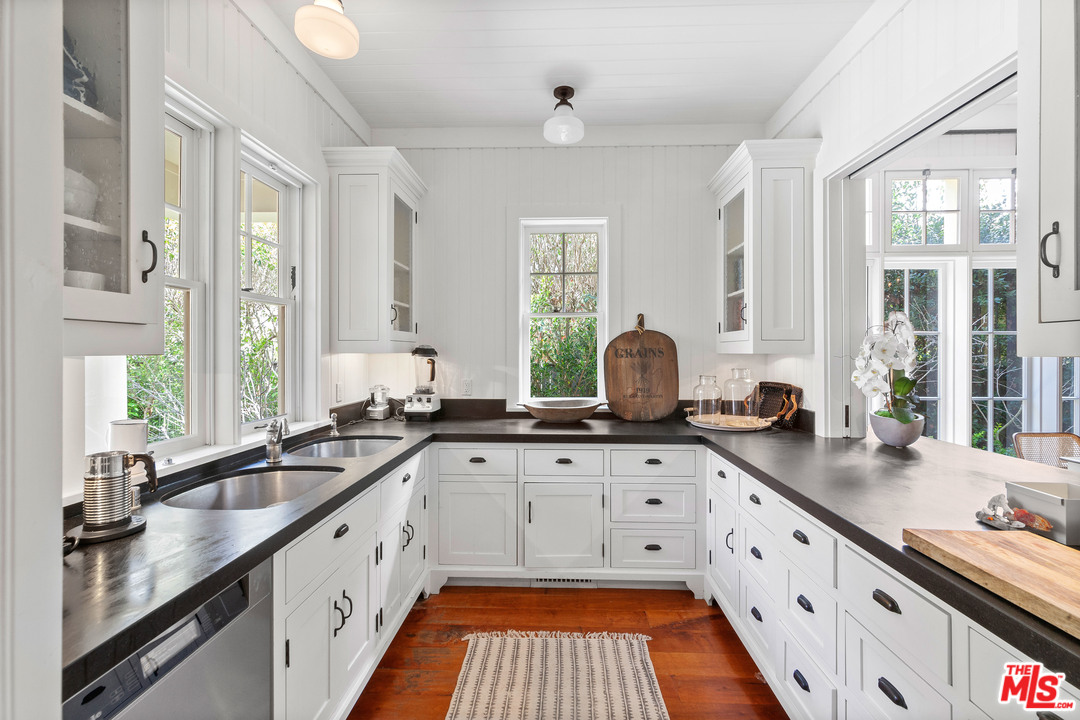 6763 Zumirez Drive Malibu, CA 90265 - Photo 18 of 52 a kitchen with granite countertop a sink stove and cabinets
