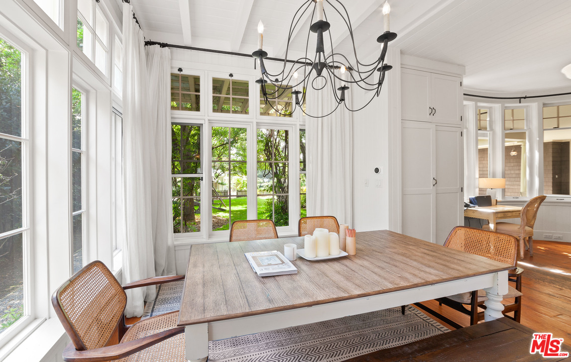 6763 Zumirez Drive Malibu, CA 90265 - Photo 20 of 52 a view of a dining room with furniture a chandelier and wooden floor