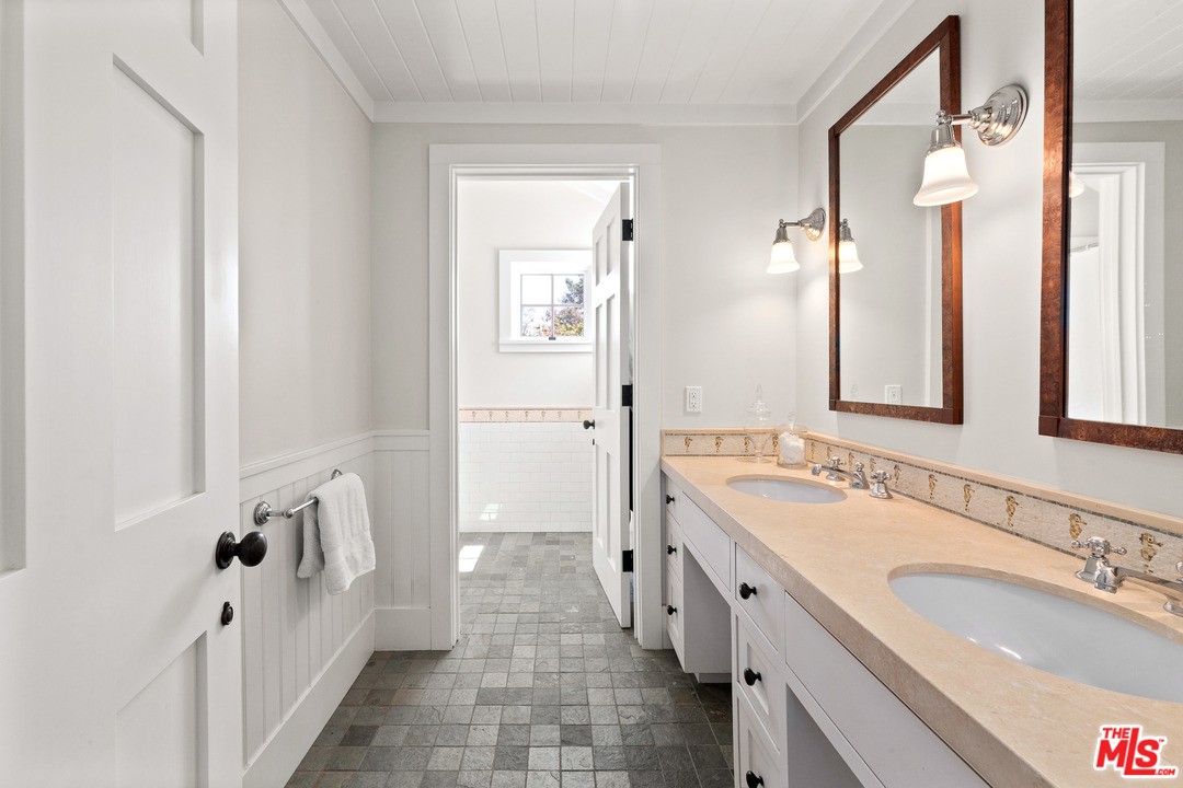 6763 Zumirez Drive Malibu, CA 90265 - Photo 25 of 52 a spacious bathroom with a double vanity sink a mirror and a bathtub