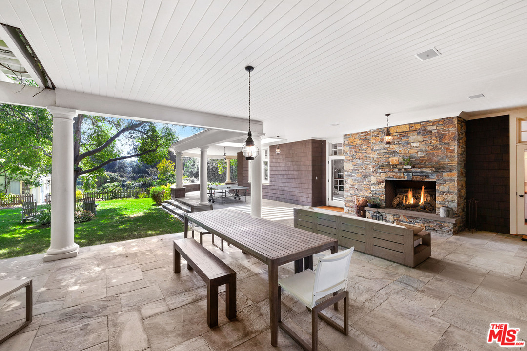 6763 Zumirez Drive Malibu, CA 90265 - Photo 30 of 52 a view of a patio with a table chairs and a backyard