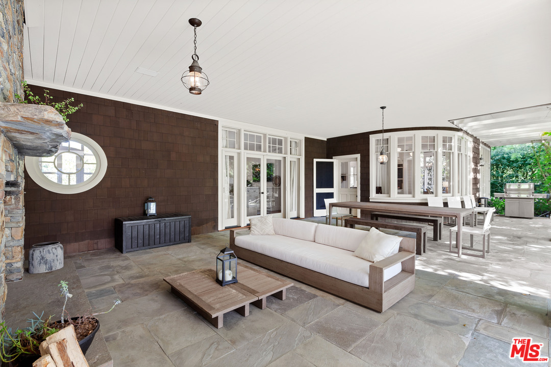 6763 Zumirez Drive Malibu, CA 90265 - Photo 31 of 52 a living room with furniture a table and a large window