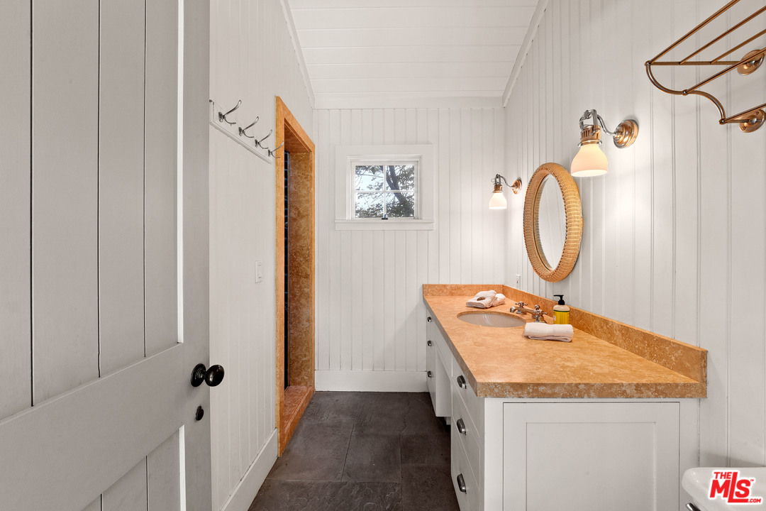 6763 Zumirez Drive Malibu, CA 90265 - Photo 40 of 52 a bathroom with a granite countertop sink and a mirror