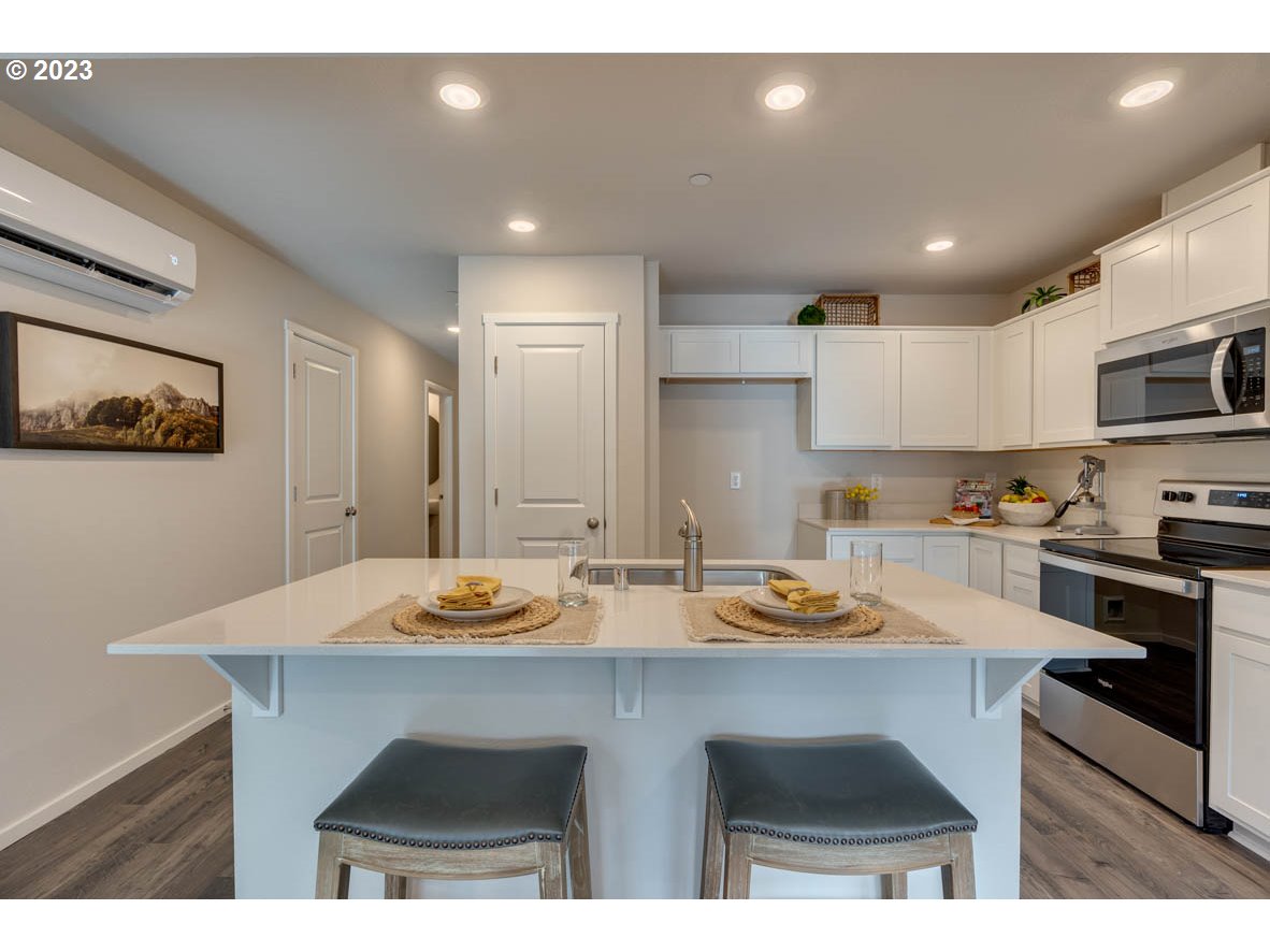 2733 North 2nd Way Ridgefield, WA 98642 - Photo 6 of 24 a kitchen with stainless steel appliances granite countertop a sink a stove a refrigerator cabinets and chairs