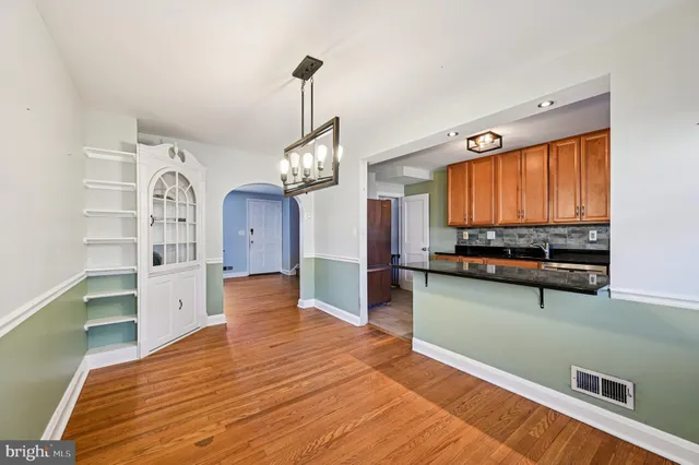 a view of a kitchen with fridge and wooden floor