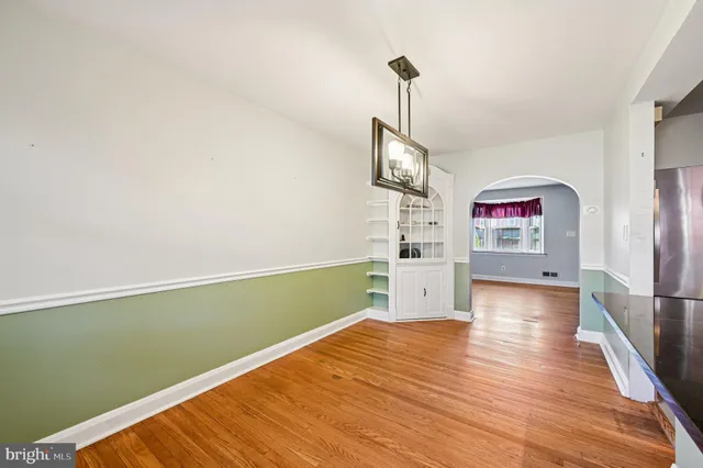 a view of a room with wooden floor ceiling fan and windows