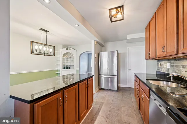 a kitchen with stainless steel appliances granite countertop a sink a stove and a refrigerator