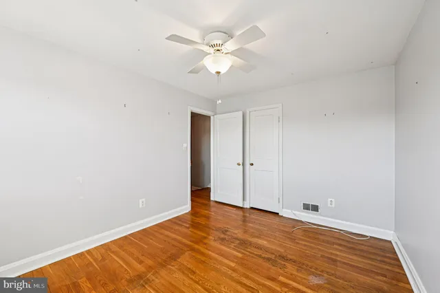 a view of a room with wooden floor and ceiling fan