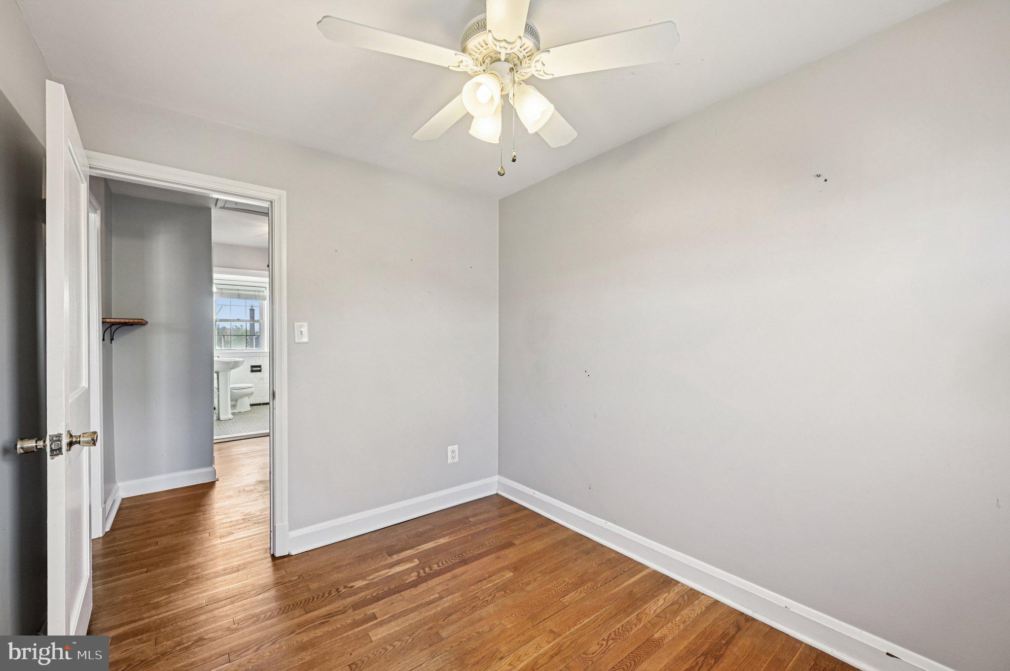 8334 Wyton Road Baltimore, MD 21286 - Photo 29 of 44 an empty room with wooden floor and fan