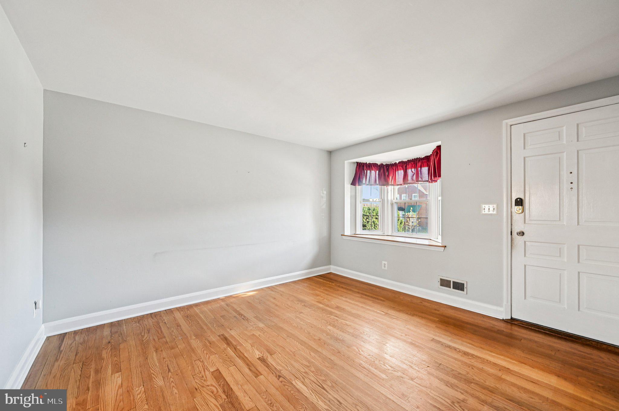 8334 Wyton Road Baltimore, MD 21286 - Photo 8 of 44 a view of an empty room with wooden floor and window
