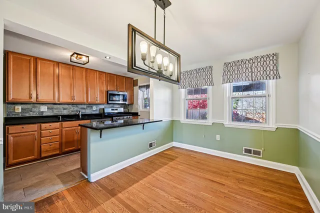 a kitchen with stainless steel appliances wooden cabinets a stove top oven a sink and dishwasher