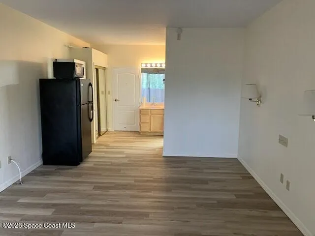 a view of empty room with wooden floor