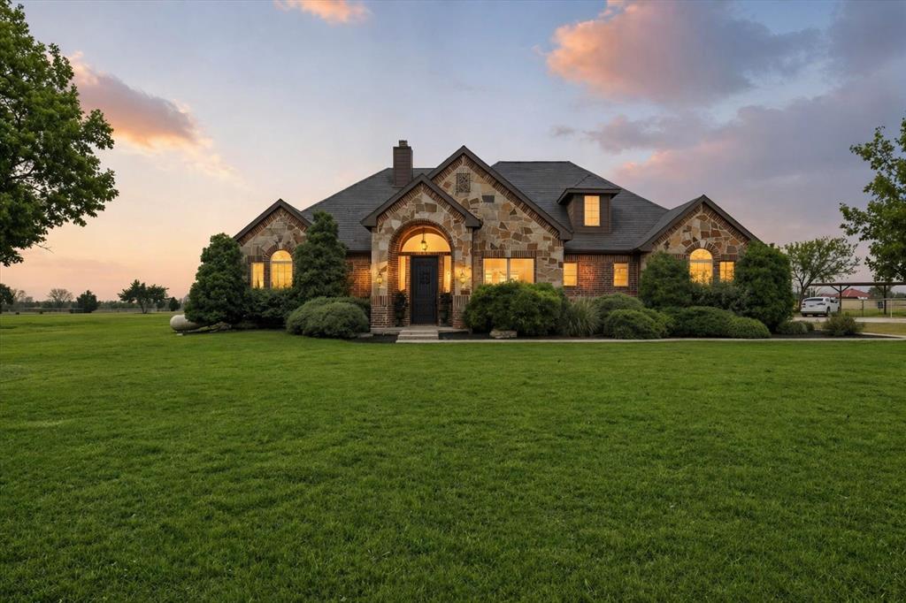 542 Pierce Road Red Oak, TX 75154 - Photo 1 of 27 Stone facade residence featuring a prominent arched entry, a dark shingle roof, and multiple dormer windows
