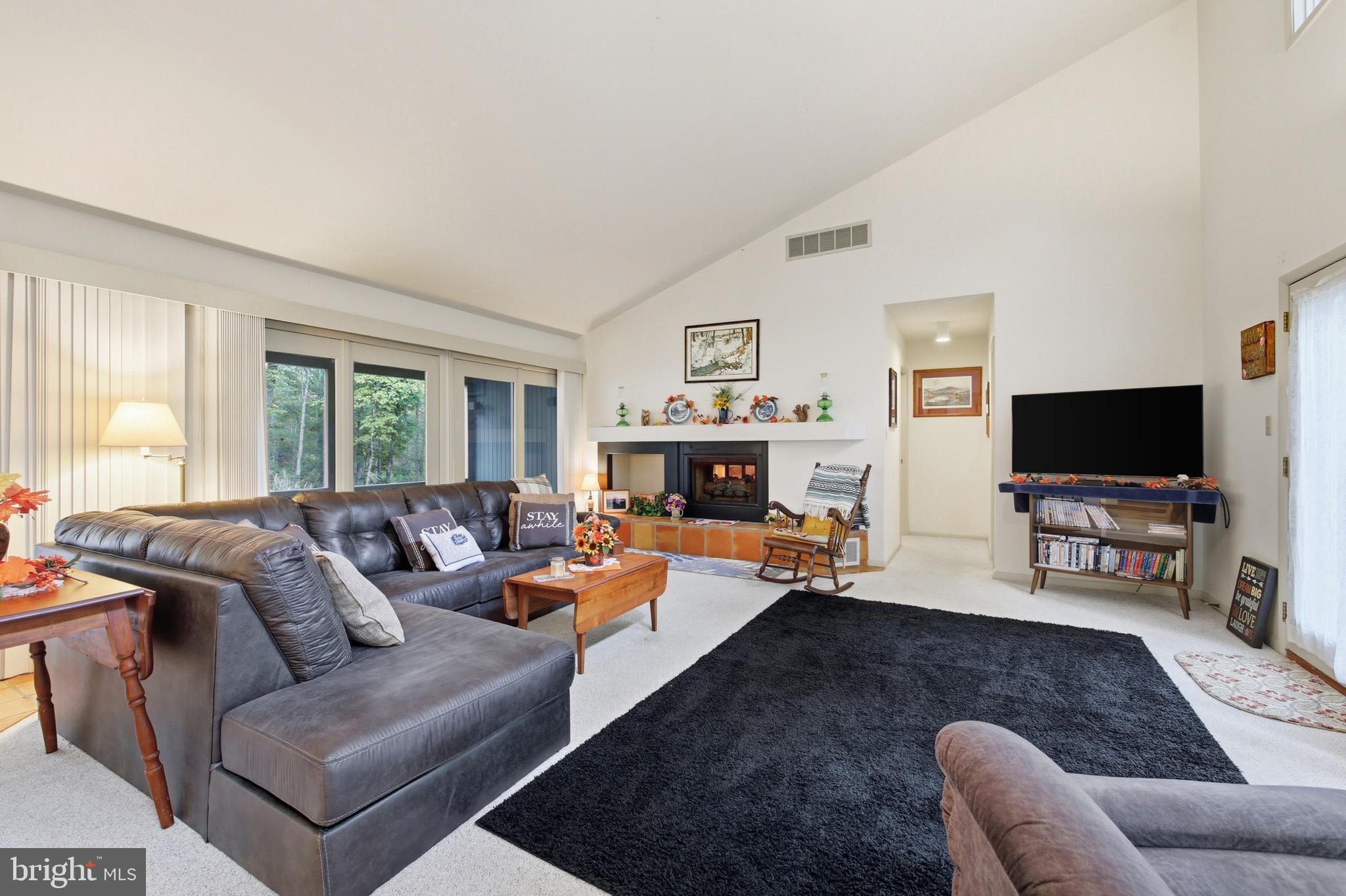 16 Spruce Hollow Road Basye, VA 22842 - Photo 17 of 50 a living room with furniture a flat screen tv and a large window