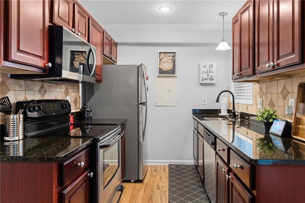 6900 Roswell Road, Unit N5 Atlanta, GA 30328 - Photo 19 of 47 a kitchen with stainless steel appliances granite countertop a stove sink and cabinets
