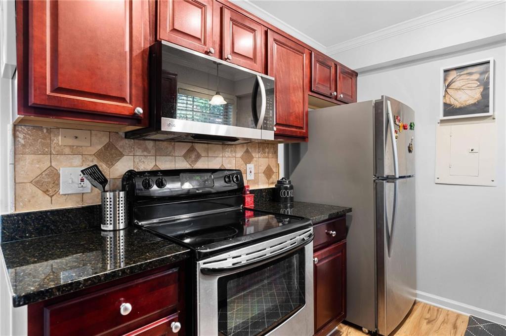 6900 Roswell Road, Unit N5 Atlanta, GA 30328 - Photo 21 of 47 a kitchen with stainless steel appliances granite countertop a stove microwave and refrigerator