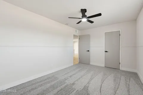 a view of a livingroom with a ceiling fan and wooden floor