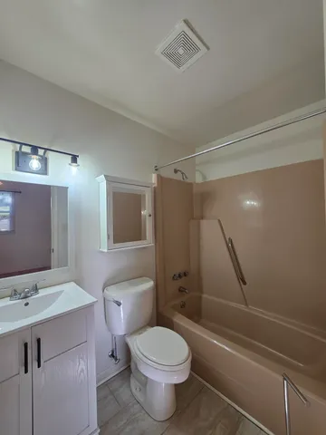 a bathroom with a sink toilet vanity and shower