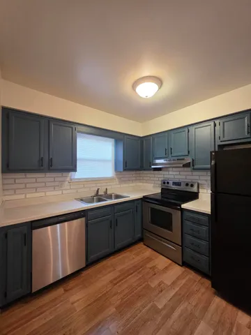 a large kitchen with stainless steel appliances granite countertop a stove and a sink