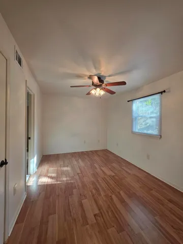 wooden floor in an empty room with a window