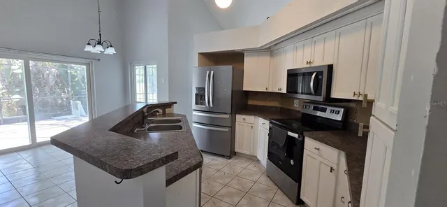a kitchen with a center island appliances and cabinets