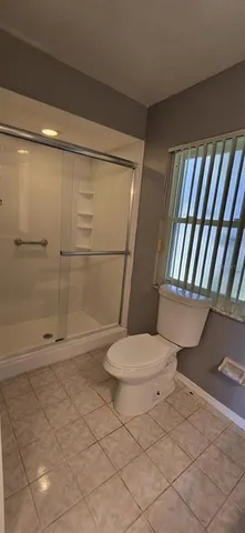 a bathroom with a toilet and a shower