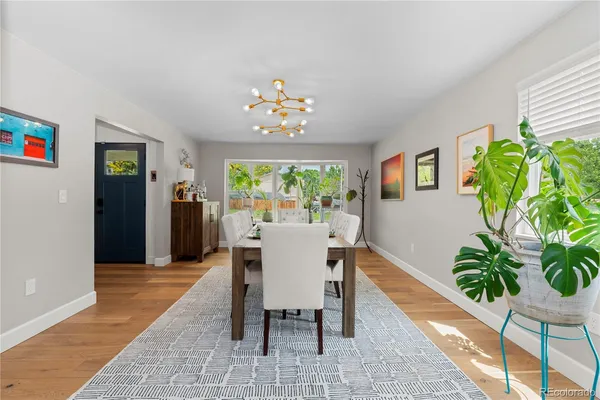 a dining room with furniture potted plants and wooden floor