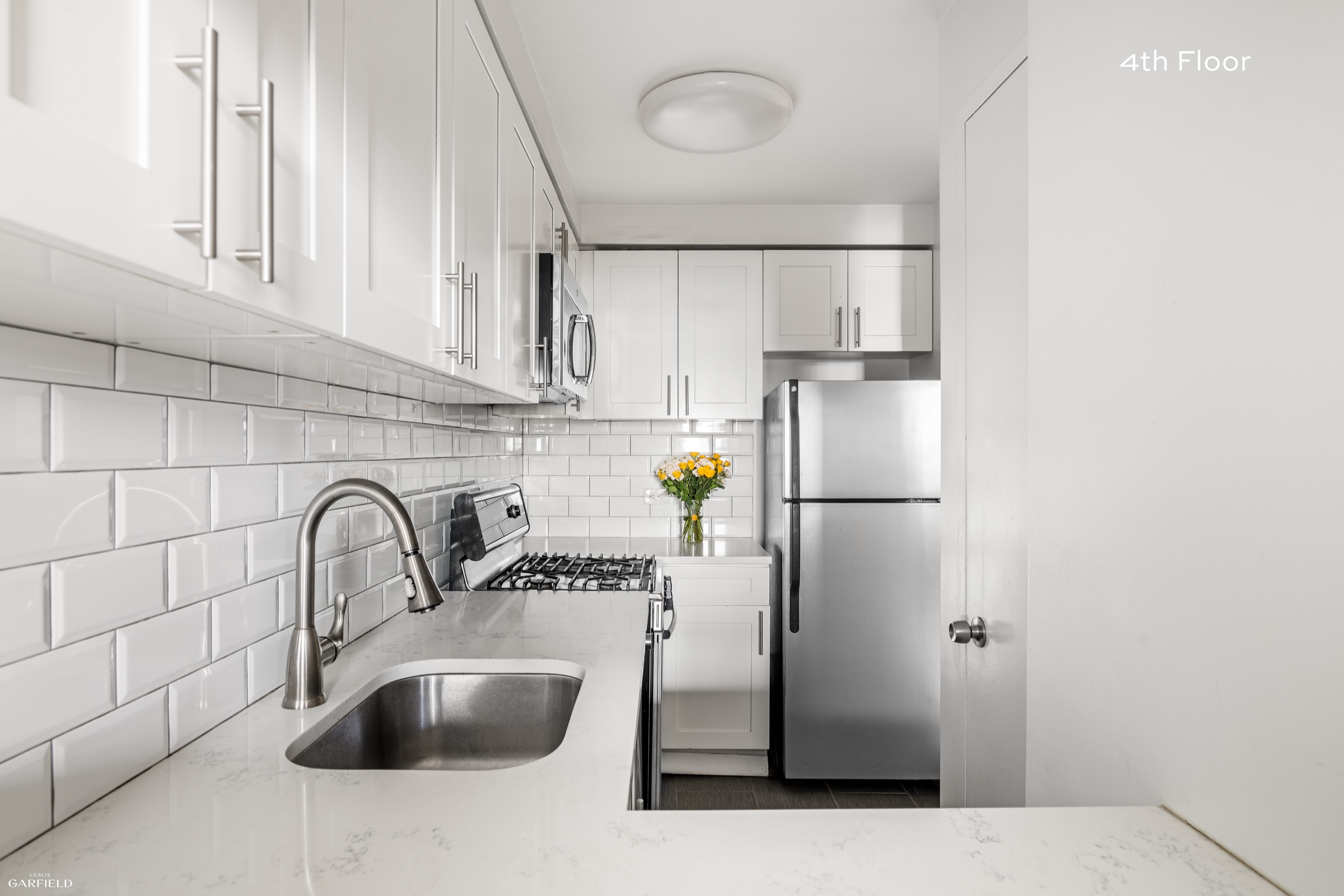 13 West 89th Street Manhattan, NY 10024 - Photo 9 of 17 a kitchen with stainless steel appliances granite countertop a sink and a refrigerator