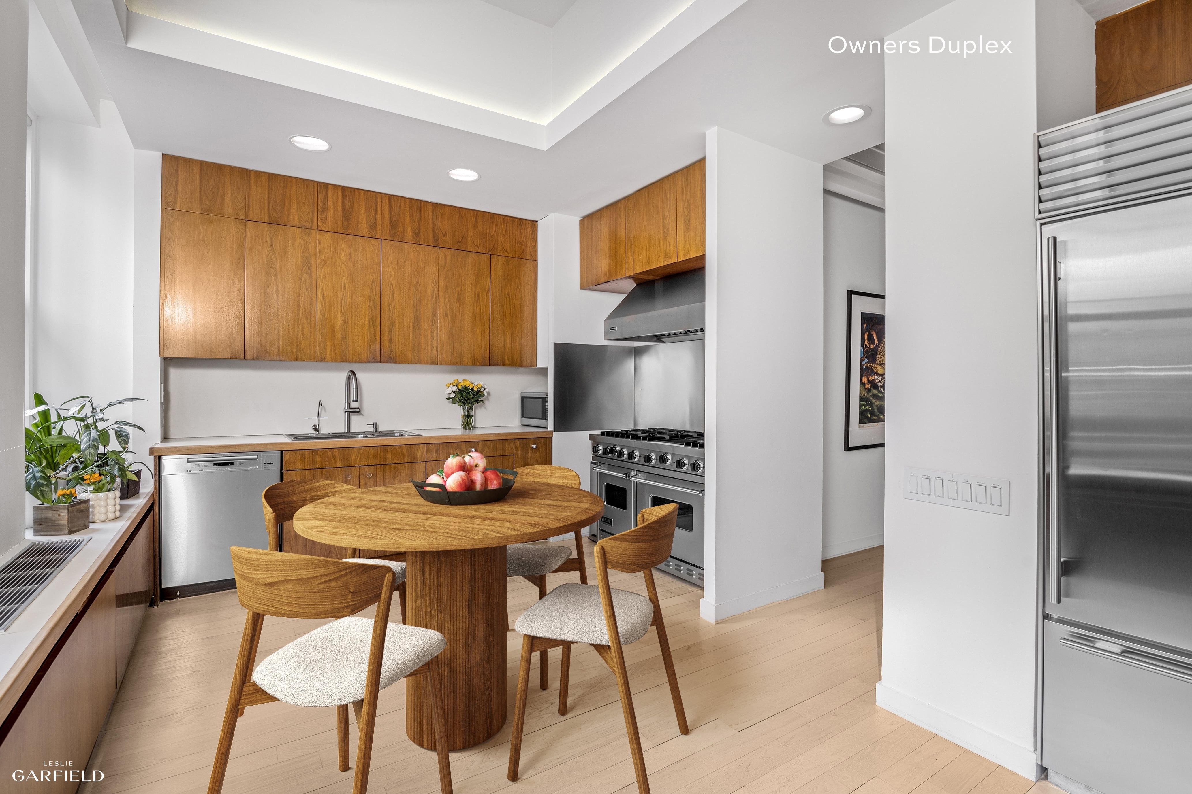 13 West 89th Street Manhattan, NY 10024 - Photo 4 of 17 a kitchen with stainless steel appliances a table and chairs in it