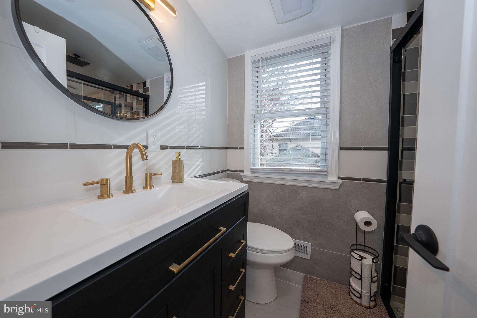 1022 Clover Hill Road Wynnewood, PA 19096 - Photo 33 of 40 a bathroom with a sink a toilet and a mirror