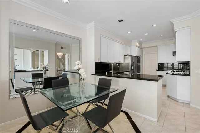 a kitchen with a dining table chairs and a refrigerator