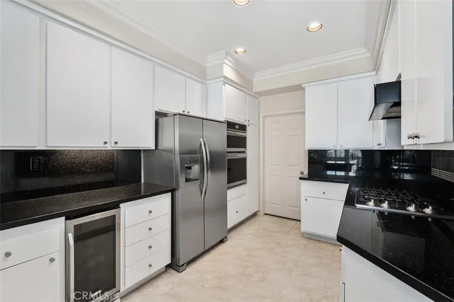 a kitchen with stainless steel appliances a stove a microwave a sink and cabinets