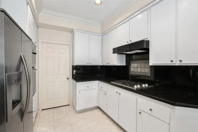 a kitchen with granite countertop a refrigerator and a sink