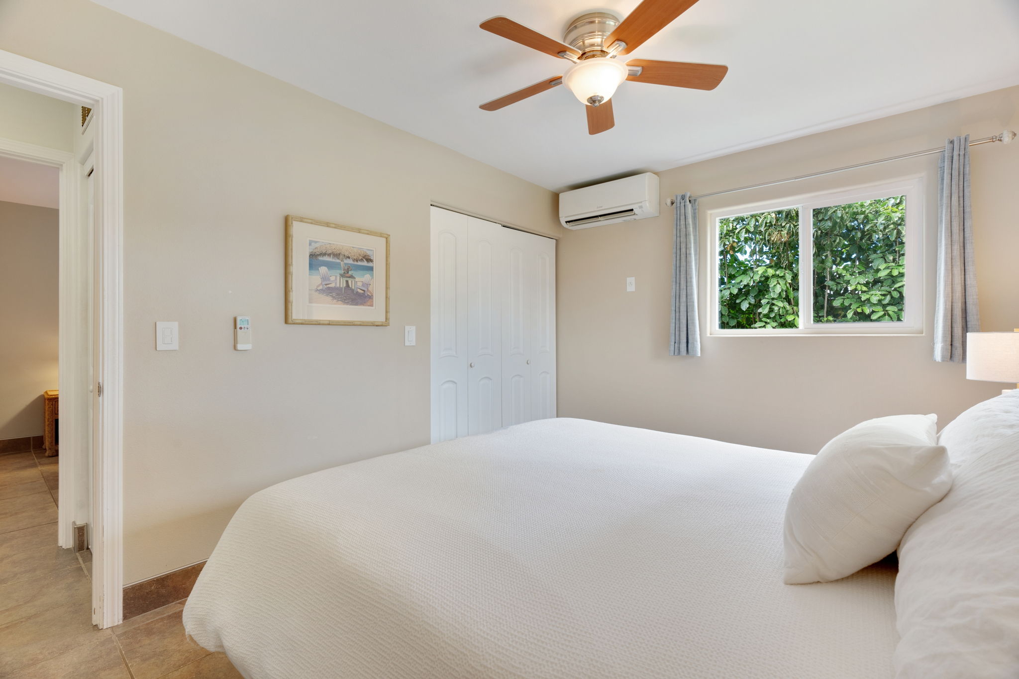 4460 Aku Road Hanalei, HI 96714 - Photo 14 of 30 a bedroom with a large bed and a chandelier