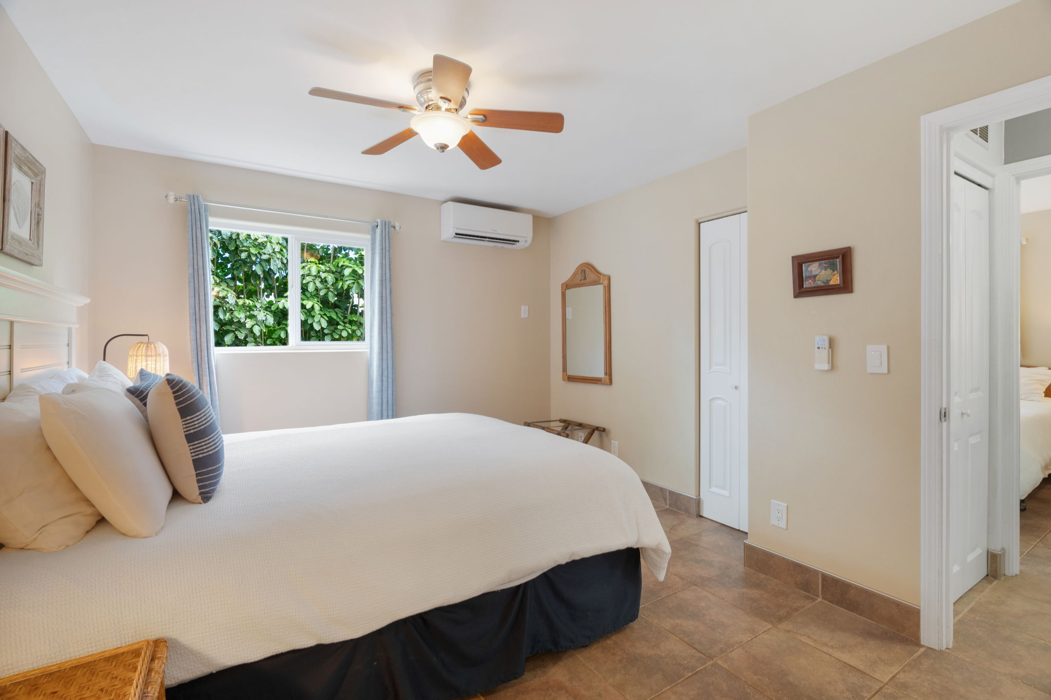 4460 Aku Road Hanalei, HI 96714 - Photo 17 of 30 a bedroom with a bed next to a window and a chandelier