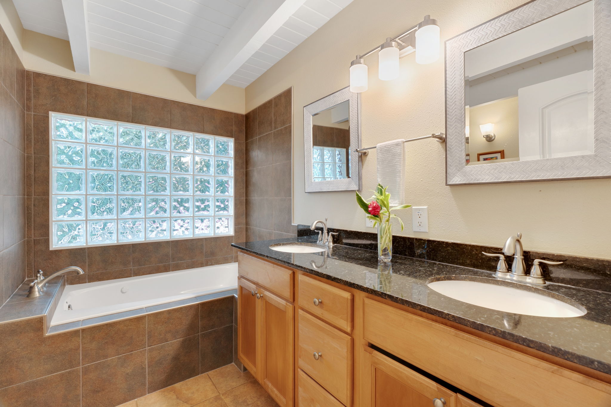 4460 Aku Road Hanalei, HI 96714 - Photo 23 of 30 a bathroom with a granite countertop tub sink and mirror