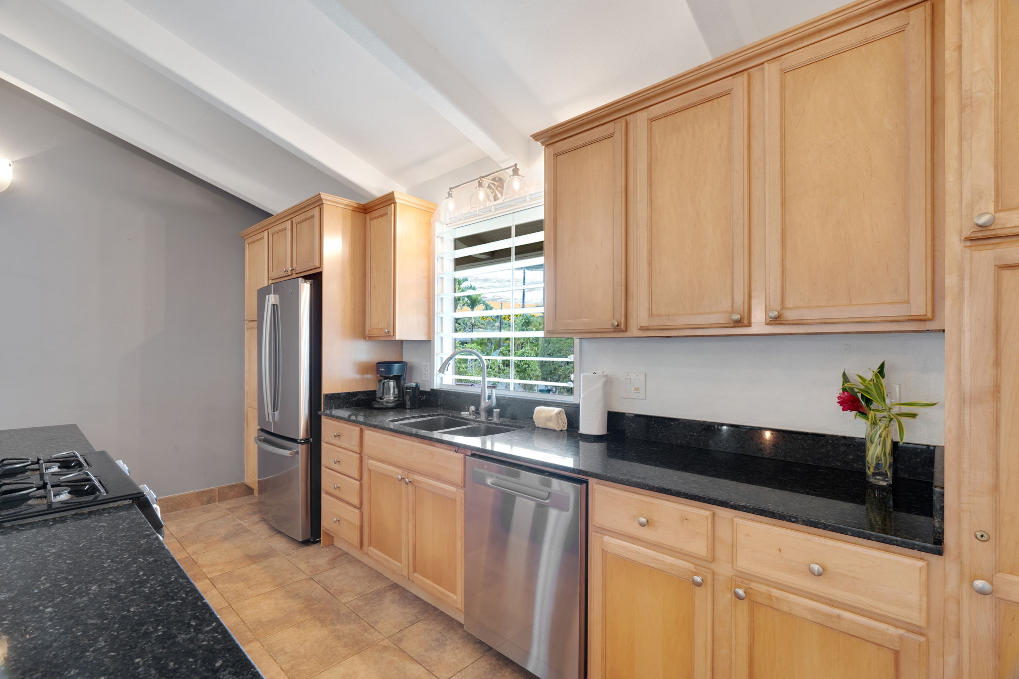 4460 Aku Road Hanalei, HI 96714 - Photo 8 of 30 a kitchen with stainless steel appliances granite countertop a sink a stove and a refrigerator