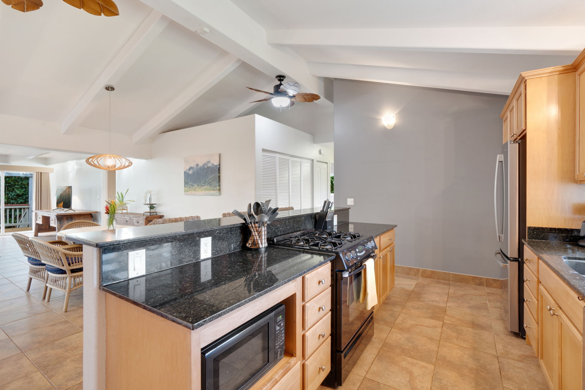 4460 Aku Road Hanalei, HI 96714 - Photo 9 of 30 a kitchen with stainless steel appliances granite countertop a sink a stove and a wooden floors
