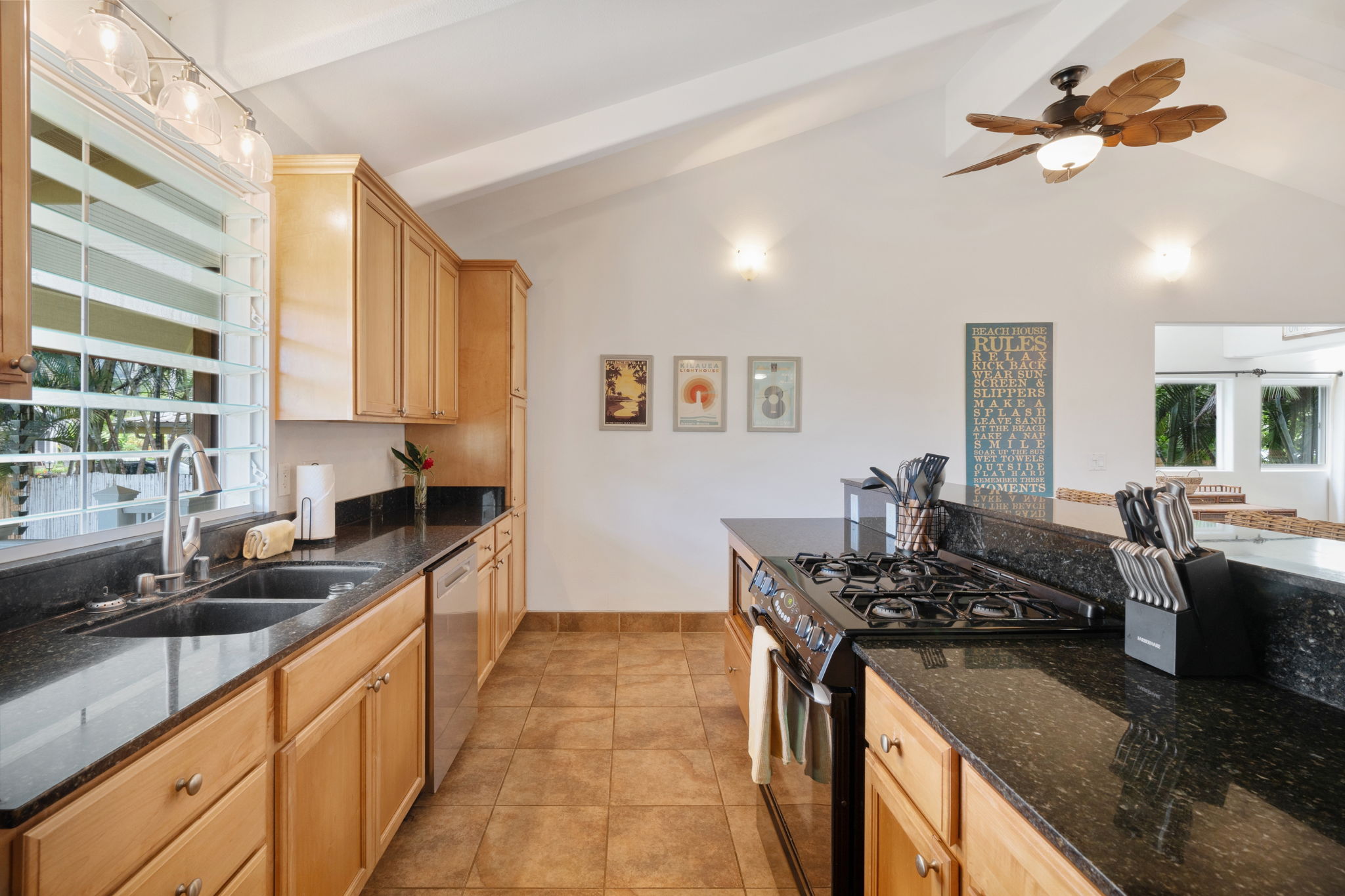 4460 Aku Road Hanalei, HI 96714 - Photo 10 of 30 a kitchen with stainless steel appliances granite countertop a sink a stove cabinets counter space and a window