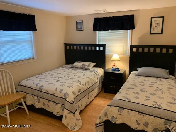 a bedroom with a bed a dresser and painting on the wall