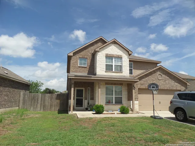 a front view of a house with a yard and trees