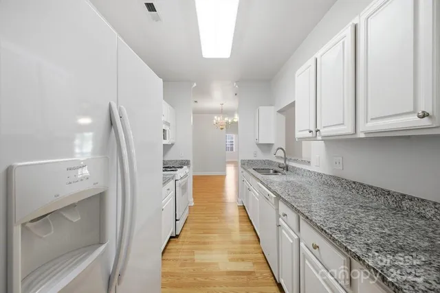 a kitchen with granite countertop a sink and cabinets