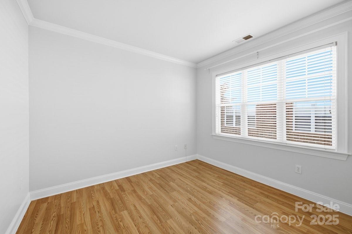 5617 Fairview Road, Unit 6 Charlotte, NC 28209 - Photo 19 of 38 a view of an empty room with wooden floor and a window