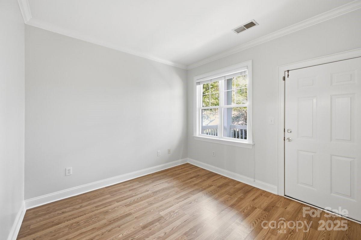 5617 Fairview Road, Unit 6 Charlotte, NC 28209 - Photo 20 of 38 a view of an empty room with wooden floor and a window