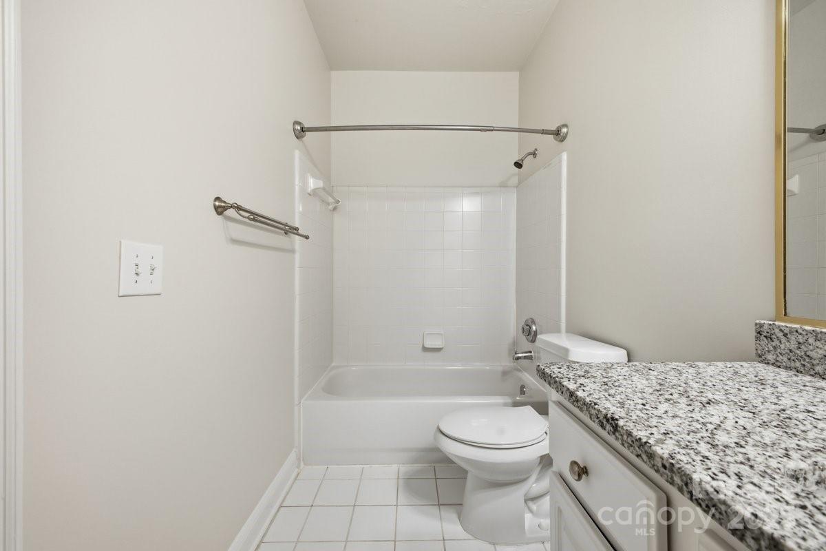 5617 Fairview Road, Unit 6 Charlotte, NC 28209 - Photo 22 of 38 a bathroom with a granite countertop sink a toilet and shower