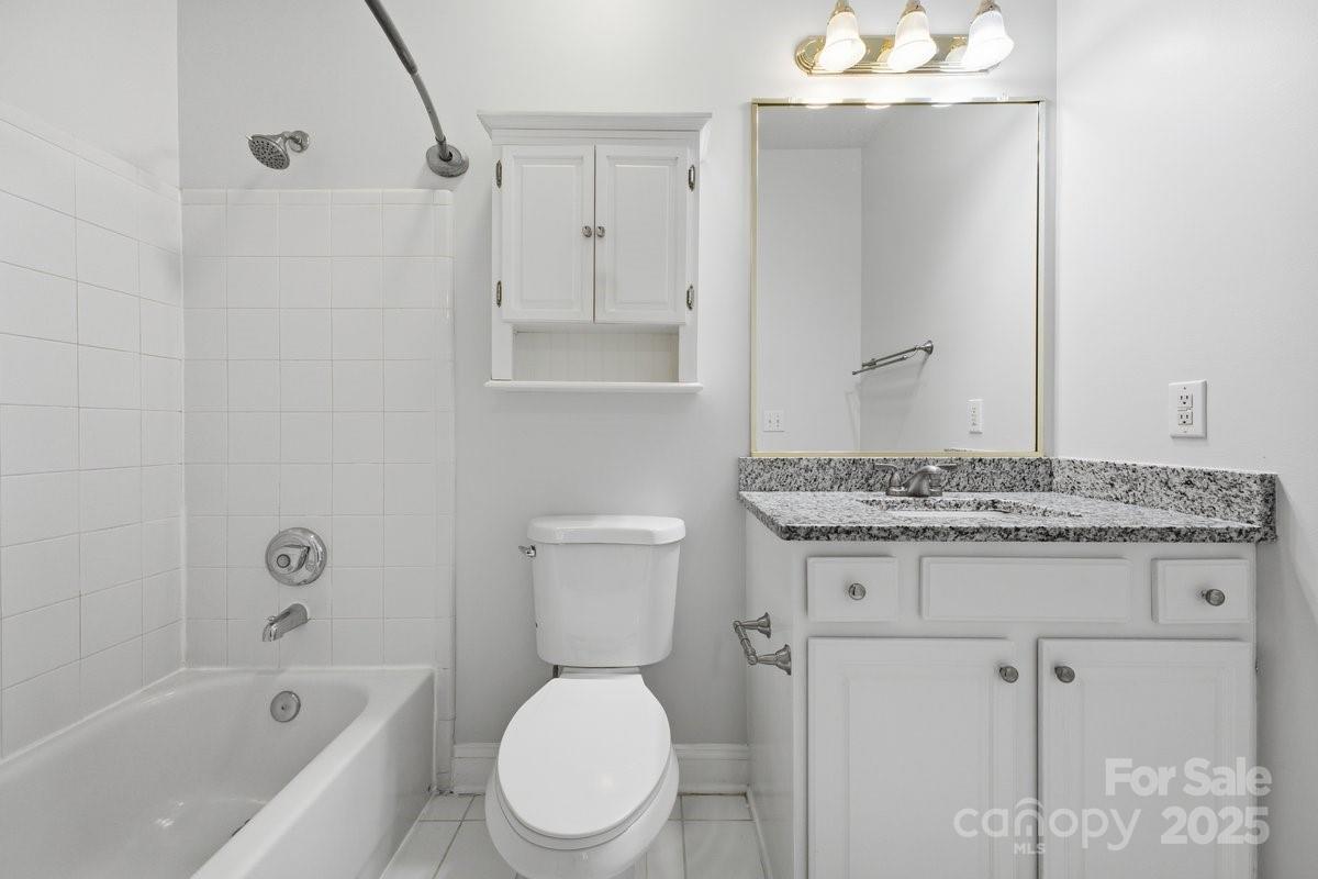 5617 Fairview Road, Unit 6 Charlotte, NC 28209 - Photo 26 of 38 a bathroom with a granite countertop toilet a sink and a bathtub