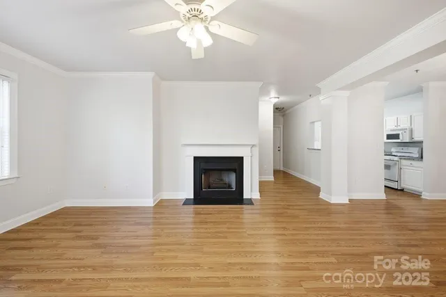 a view of a livingroom with a fireplace a chandelier and wooden floor