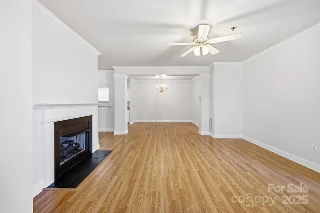 a view of a livingroom with wooden floor and a fireplace