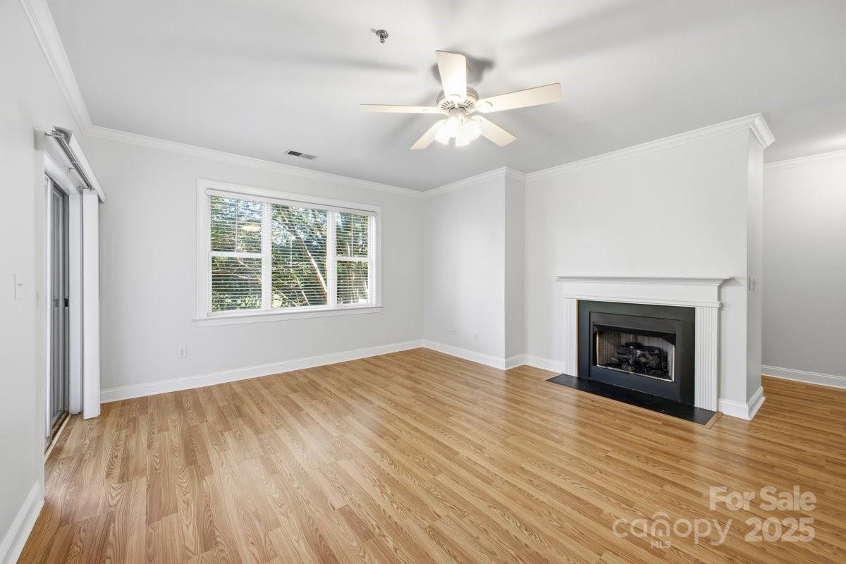 5617 Fairview Road, Unit 6 Charlotte, NC 28209 - Photo 7 of 38 an empty room with windows fireplace and wooden floor